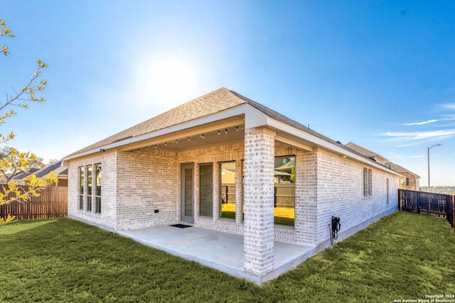 back of property with a patio and a lawn