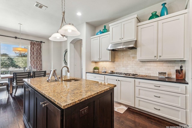 kitchen featuring sink, white cabinetry, decorative light fixtures, an island with sink, and stainless steel gas stovetop