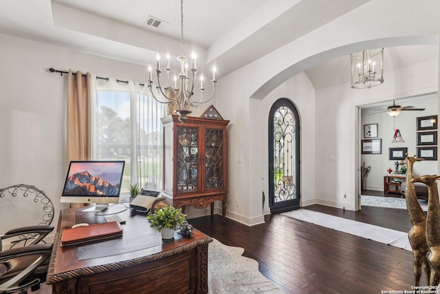 office area with a tray ceiling, dark hardwood / wood-style flooring, and ceiling fan with notable chandelier