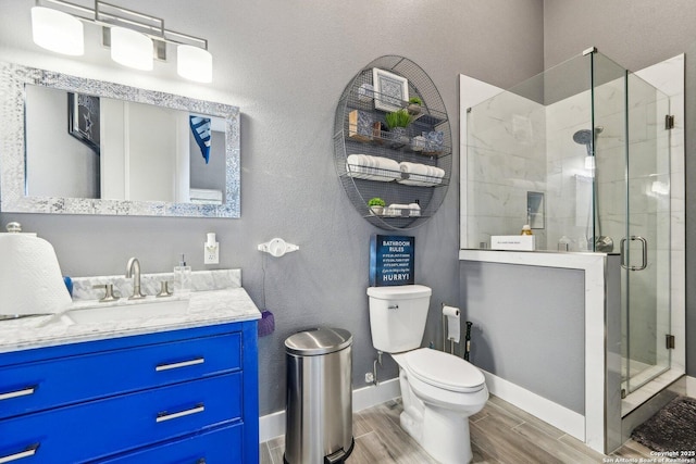 bathroom featuring vanity, an enclosed shower, and toilet