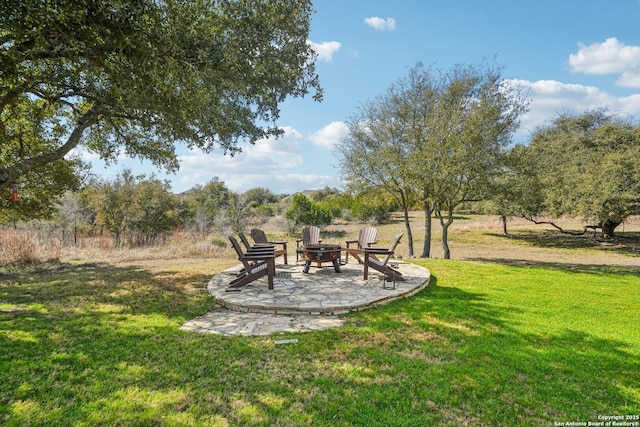 view of yard featuring a fire pit and a patio