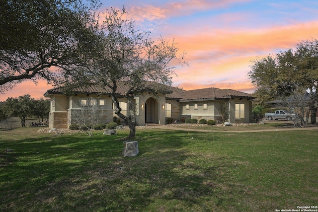 mediterranean / spanish home with a yard