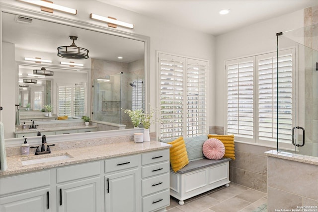 full bath featuring a shower stall, visible vents, and a wealth of natural light