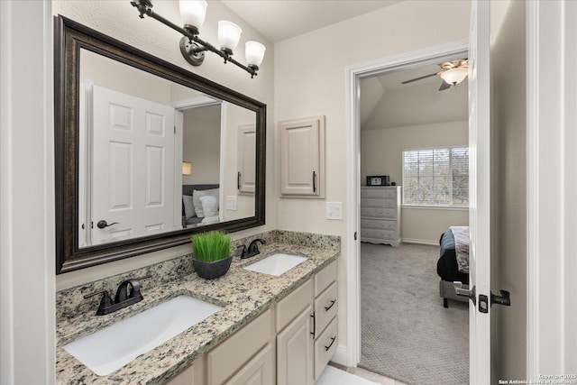 bathroom with a sink, double vanity, connected bathroom, and baseboards