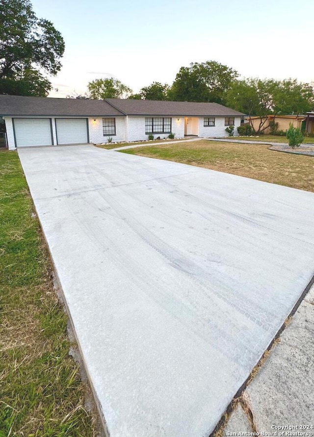 single story home featuring a garage and a front yard