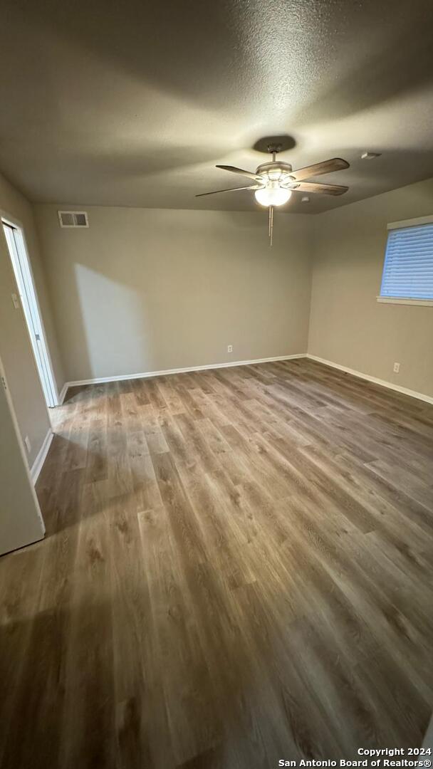 spare room with hardwood / wood-style floors, a textured ceiling, and ceiling fan