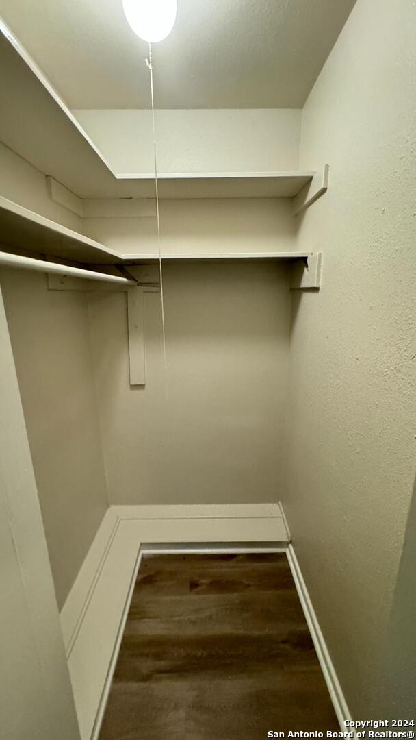 spacious closet with dark hardwood / wood-style flooring