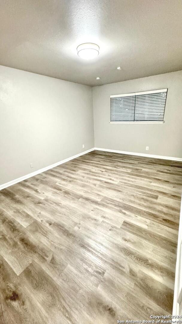 spare room with hardwood / wood-style flooring and a textured ceiling