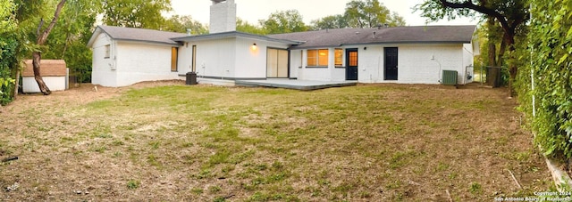 rear view of property with a shed, cooling unit, a lawn, and a patio