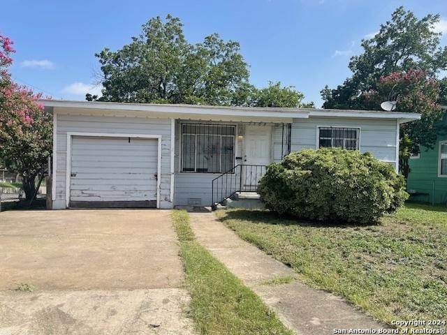 single story home featuring a garage and a front lawn