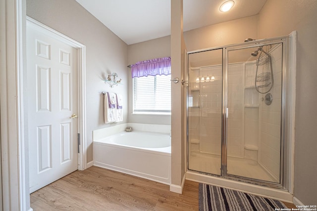 bathroom featuring wood-type flooring and separate shower and tub