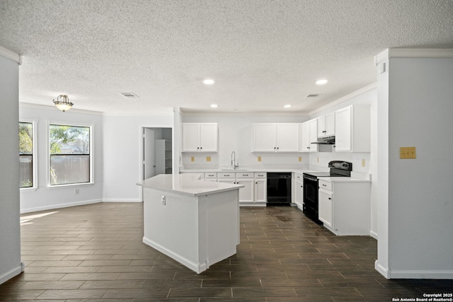 kitchen featuring sink, white cabinetry, a center island, ornamental molding, and black appliances