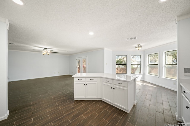 kitchen featuring white cabinetry, ceiling fan, crown molding, and a center island