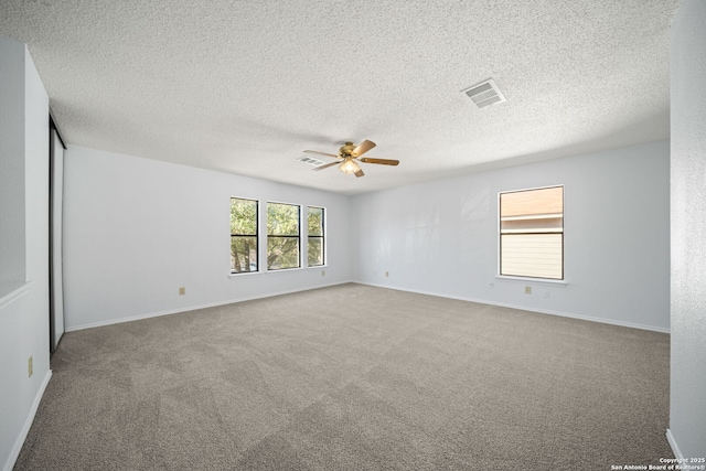 unfurnished room with ceiling fan, carpet floors, and a textured ceiling