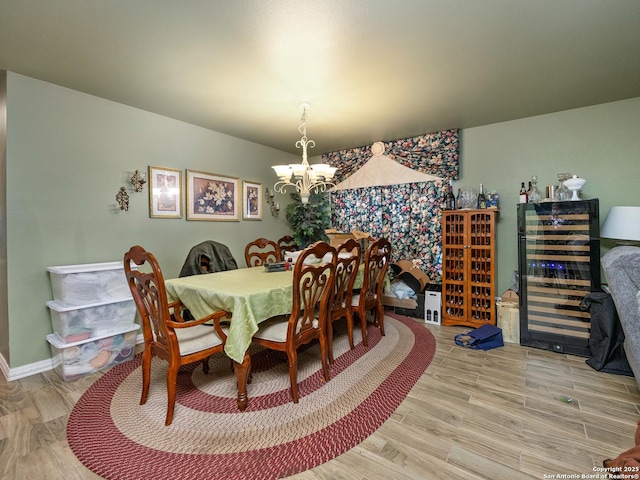 dining area with hardwood / wood-style flooring and an inviting chandelier