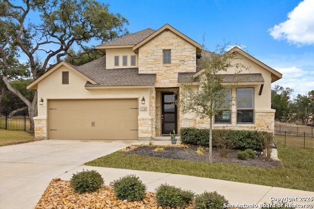 view of front of home with an attached garage, stone siding, fence, and concrete driveway