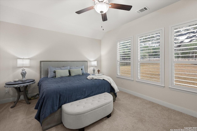 carpeted bedroom with visible vents, vaulted ceiling, baseboards, and ceiling fan