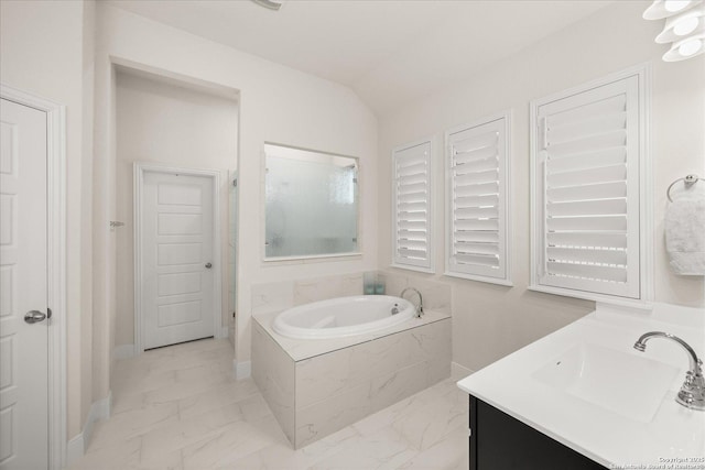 bathroom featuring lofted ceiling, vanity, baseboards, marble finish floor, and a bath