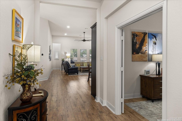 hallway with hardwood / wood-style flooring, baseboards, and recessed lighting