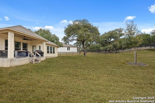 view of yard with ceiling fan and fence