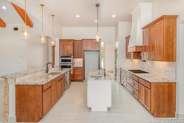 kitchen with premium range hood, sink, pendant lighting, and double oven