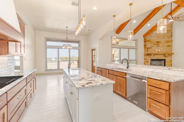 kitchen featuring sink, white cabinets, hanging light fixtures, stainless steel dishwasher, and a center island with sink