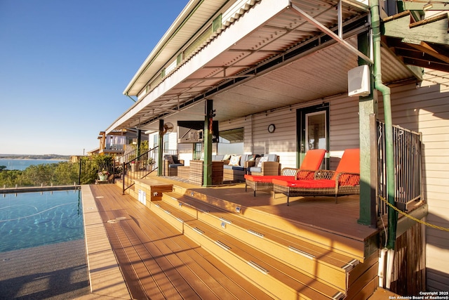 wooden terrace with a water view and an outdoor living space