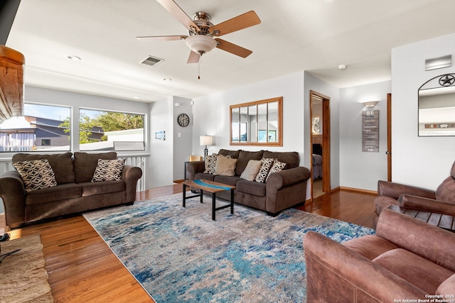 living room featuring wood-type flooring and ceiling fan