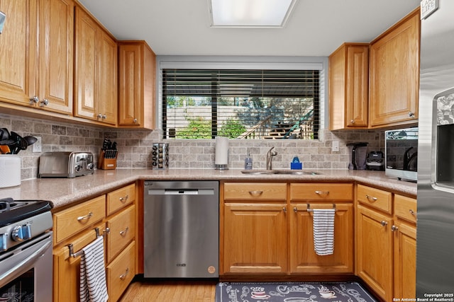 kitchen with tasteful backsplash, a healthy amount of sunlight, appliances with stainless steel finishes, and sink