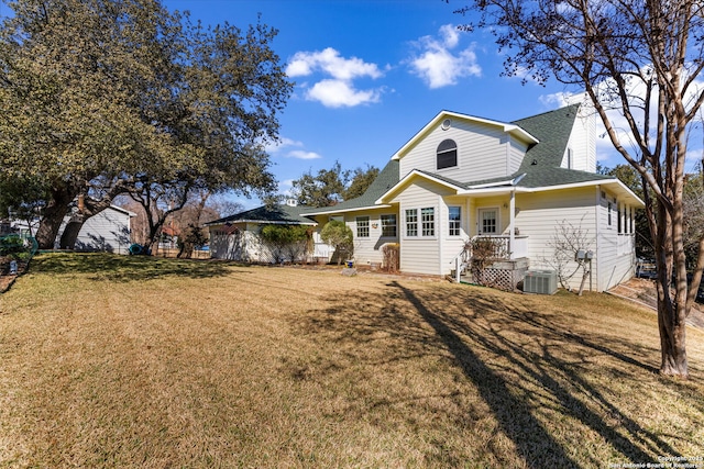 view of front of house featuring central AC unit and a front lawn