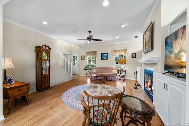 living room featuring ornamental molding, ceiling fan, and light hardwood / wood-style floors