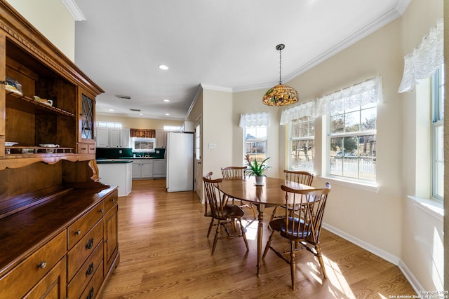 dining room featuring crown molding and light wood-type flooring