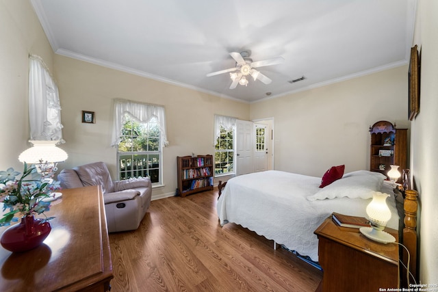 bedroom with hardwood / wood-style flooring, ceiling fan, and ornamental molding