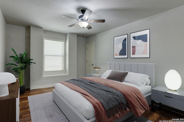 bedroom with ceiling fan and dark hardwood / wood-style flooring