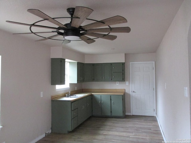 kitchen with ceiling fan, sink, and light hardwood / wood-style flooring