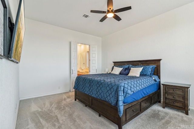 bedroom featuring ensuite bathroom, baseboards, visible vents, and light colored carpet