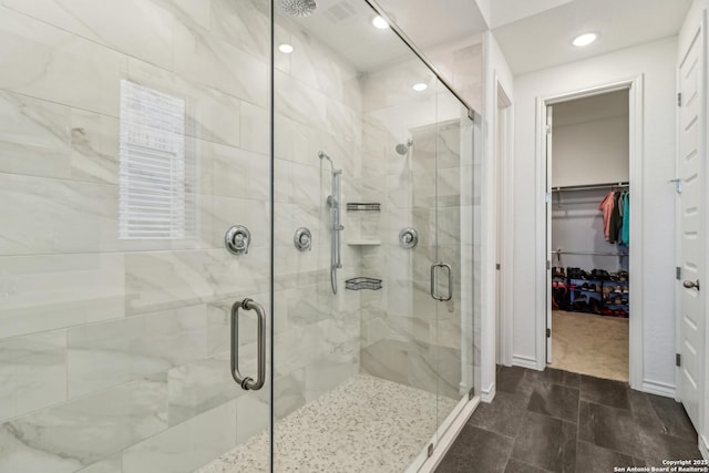 bathroom featuring recessed lighting, a shower stall, and a spacious closet