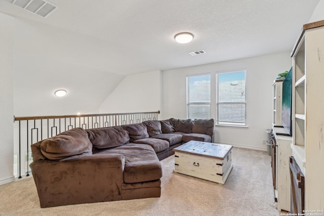 living room with baseboards, visible vents, vaulted ceiling, and light colored carpet