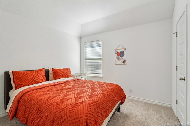 bedroom with lofted ceiling, carpet flooring, and baseboards