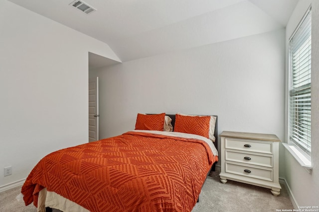 carpeted bedroom featuring visible vents, vaulted ceiling, baseboards, and multiple windows