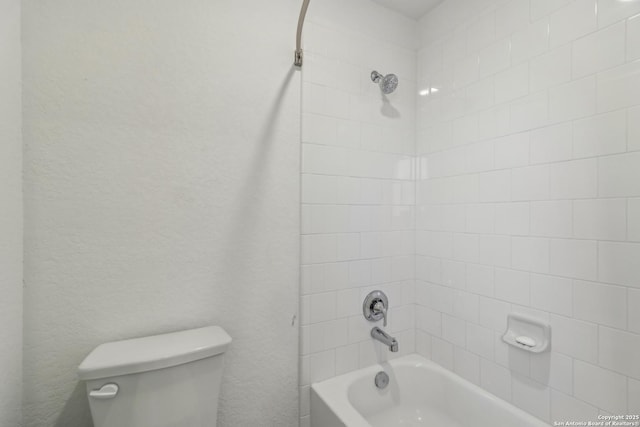 full bathroom featuring a textured wall, shower / tub combination, and toilet