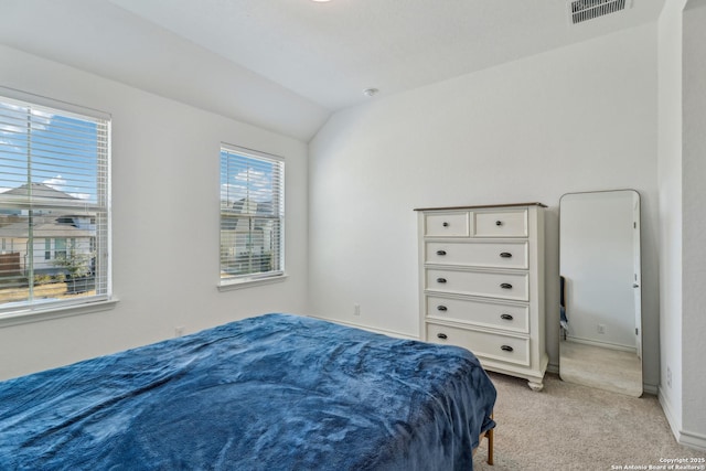 bedroom with light colored carpet, visible vents, vaulted ceiling, and baseboards