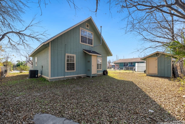 back of property featuring central AC and a shed