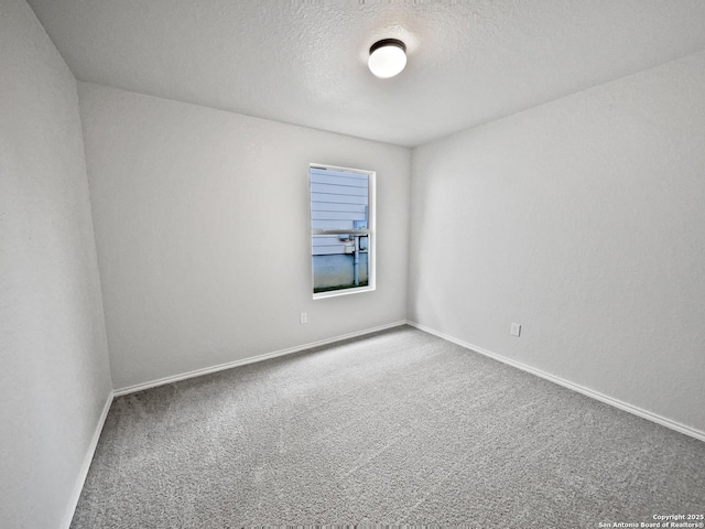 empty room with carpet flooring and a textured ceiling