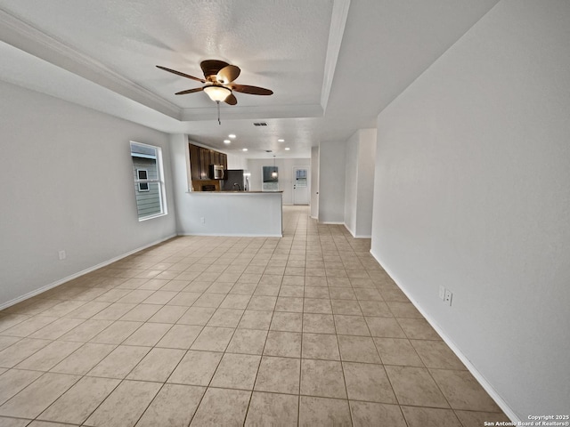 unfurnished living room featuring light tile patterned flooring, ceiling fan, a tray ceiling, crown molding, and a textured ceiling