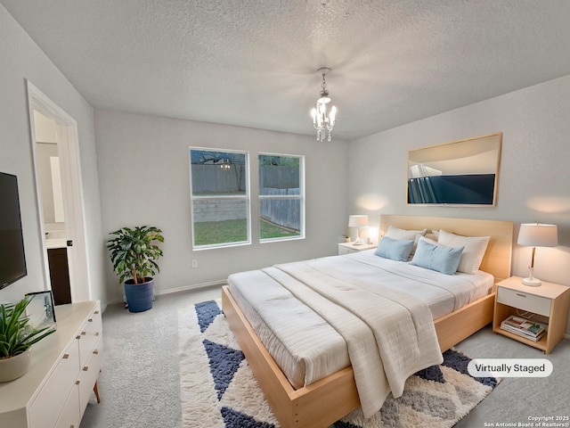 carpeted bedroom featuring a chandelier and a textured ceiling