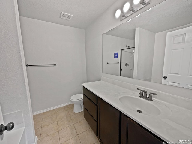 bathroom featuring a shower, tile patterned flooring, vanity, toilet, and a textured ceiling