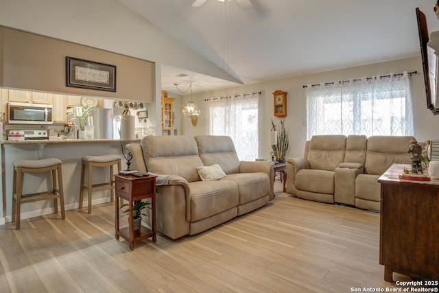 living room featuring ceiling fan, high vaulted ceiling, and light hardwood / wood-style floors