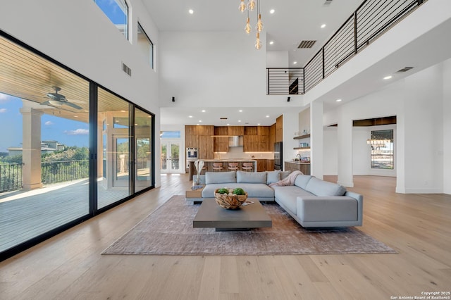 living room with a towering ceiling and light hardwood / wood-style floors