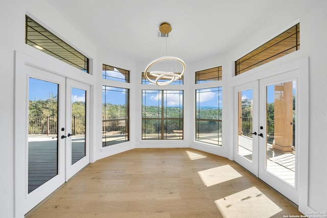 unfurnished sunroom featuring a notable chandelier and french doors